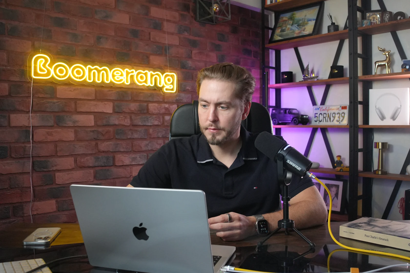 Mike recording a video with a microphone and laptop in the Boomerang studio